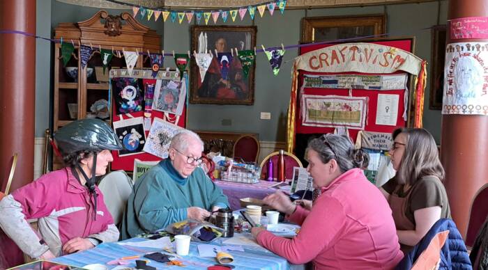 Crafty ladies sat at a table making bunting