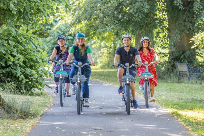 R6__4987_19Jun2025 (1) People riding Beryl bikes on a riverside path
